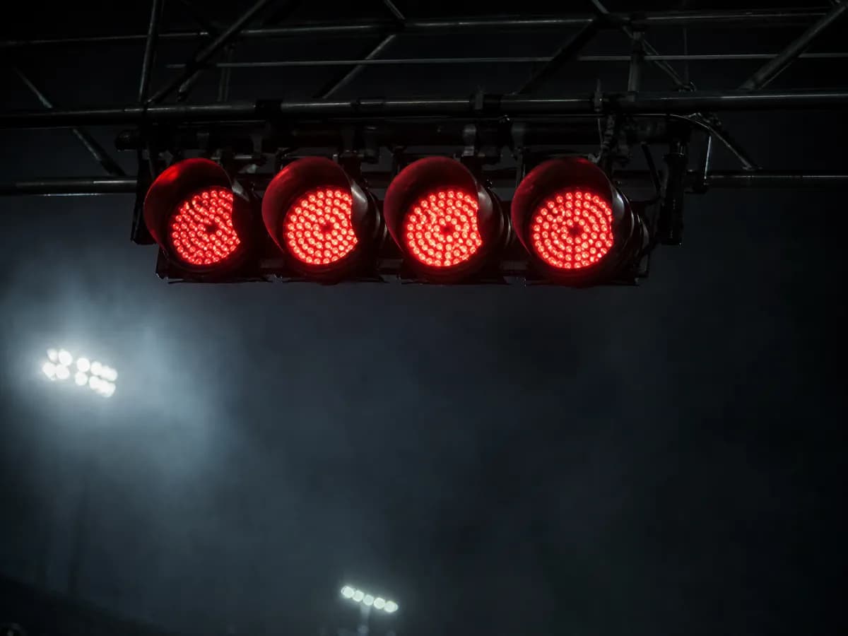 Five red start lights glowing on a gantry at night